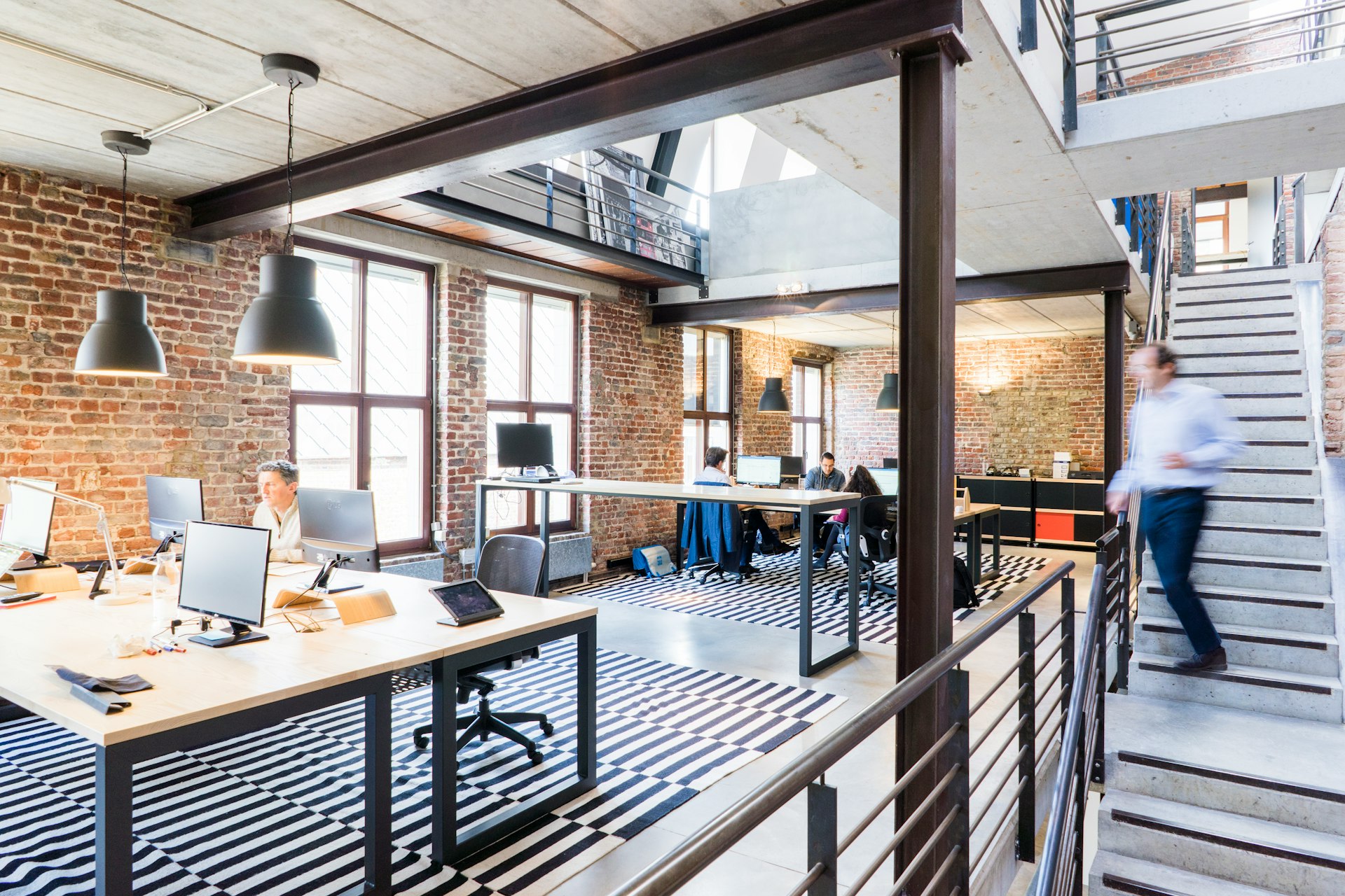 View into modern, open office space, man walking on stairs